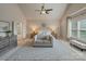 Bright main bedroom features a vaulted ceiling, ceiling fan, sitting area, and neutral tones at 9069 Blue Ridge Dr, Indian Land, SC 29707