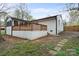 Rear exterior showcasing a deck and a white brick house with a black roof at 908 Woodside Dr, Kings Mountain, NC 28086