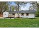 Charming single-story home with a white brick exterior, dark roof, and inviting front porch at 908 Woodside Dr, Kings Mountain, NC 28086