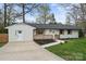 Inviting single-story home featuring a white brick facade, dark roof, and a concrete driveway at 908 Woodside Dr, Kings Mountain, NC 28086