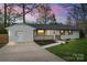 Inviting single-story home featuring a white brick facade, dark roof, and a concrete driveway at 908 Woodside Dr, Kings Mountain, NC 28086