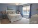 Comfortable bedroom with blue walls, white furnishings, and a window with natural light at 9319 Kestral Ridge Dr, Charlotte, NC 28269