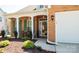 Charming front porch with brick facade, decorative shutters, small seating area, and well-manicured landscaping at 9319 Kestral Ridge Dr, Charlotte, NC 28269