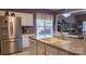 Bright kitchen with stainless steel appliances, stone counters, and a breakfast bar overlooking dining area at 9319 Kestral Ridge Dr, Charlotte, NC 28269