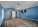 Primary bedroom featuring vaulted ceilings, barn door access to ensuite bathroom and large screen TV at 98 Poplar Woods Dr, Concord, NC 28027