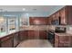 Well-lit kitchen featuring stainless steel appliances, dark cabinets, and stone-look countertops at 98 Poplar Woods Dr, Concord, NC 28027