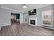 Cozy living room with a fireplace, modern wood flooring, and an open view to the dining area at 98 Poplar Woods Dr, Concord, NC 28027