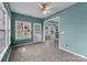Bright living room featuring three large windows, a ceiling fan, and easy access to other living spaces at 98 Poplar Woods Dr, Concord, NC 28027