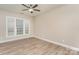 A bright bedroom featuring neutral walls, wood-look flooring, and a window at 10325 Merlin Meadows Ct, Charlotte, NC 28277