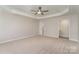 A primary bedroom boasts a tray ceiling, ceiling fan, and a walk-in closet at 10325 Merlin Meadows Ct, Charlotte, NC 28277