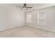 Bright bedroom featuring neutral carpet, a ceiling fan, and two windows for ample natural light at 10325 Merlin Meadows Ct, Charlotte, NC 28277