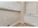 Convenient laundry room with ample storage cabinets and a sink area near a window at 10325 Merlin Meadows Ct, Charlotte, NC 28277