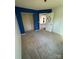 Bedroom featuring carpeted floors, blue accent wall, neutral walls, an empty closet, and an open doorway at 104 Edgewater Nw Dr, Concord, NC 28027