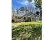 Beautiful single-story home with a gray exterior, lush green lawn, and mature trees at 104 Edgewater Nw Dr, Concord, NC 28027