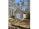 Exterior view of detached storage shed in a backyard wooded setting at 104 Edgewater Nw Dr, Concord, NC 28027