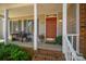 Inviting front porch with decorative features, a cozy bench, and an orange front door at 107 Southfork Dr, Belmont, NC 28012