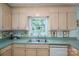 The kitchen features a stainless steel sink, wooden cabinets, and a window with green countertop at 107 Southfork Dr, Belmont, NC 28012