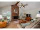 Bright living room featuring a brick fireplace, ceiling fan, and comfortable seating arrangement at 107 Southfork Dr, Belmont, NC 28012