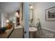 Charming powder room with a pedestal sink, decorative mirror, and views into the sitting room at 107 Southfork Dr, Belmont, NC 28012