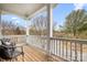 Inviting covered balcony with wood flooring and two black chairs overlooking the street at 11204 Arlen Park Dr, Huntersville, NC 28078