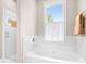 Bright bathroom features a white soaking tub, tiled shower and a window with natural light at 11204 Arlen Park Dr, Huntersville, NC 28078