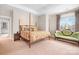Spacious bedroom featuring a four-poster bed, decorative pillows and a comfortable green settee at 11204 Arlen Park Dr, Huntersville, NC 28078