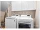 Functional laundry room with modern washer and dryer, and overhead cabinets at 11204 Arlen Park Dr, Huntersville, NC 28078