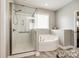 This bathroom features a glass shower and a corner soaking tub with natural light at 1129 Black Walnut Rd, Clover, SC 29710