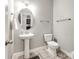 Powder room features a pedestal sink, oval mirror, and tiled floor at 1129 Black Walnut Rd, Clover, SC 29710