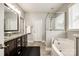 Bathroom featuring a double vanity, soaking tub, glass-enclosed shower, and natural light at 1129 Black Walnut Rd, Clover, SC 29710