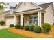 Inviting front porch with rocking chairs, manicured bushes, and brick facade with decorative columns at 1129 Black Walnut Rd, Clover, SC 29710