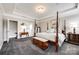 Spacious main bedroom with four-poster bed, tray ceiling, sitting area, and ensuite bathroom access at 1129 Black Walnut Rd, Clover, SC 29710