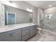 Bathroom features a double sink vanity, a large mirror and tiled shower at 11939 Fiddlers Roof Ln, Charlotte, NC 28277