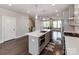 View of the modern kitchen, gray cabinets, kitchen island and open floorplan at 11939 Fiddlers Roof Ln, Charlotte, NC 28277