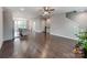 Spacious living room with dark hardwood floors, staircase, open to kitchen, and ceiling fan at 11939 Fiddlers Roof Ln, Charlotte, NC 28277