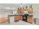This kitchen features wooden cabinets, a black range and a connecting room at 120 Vermillion Loop, Statesville, NC 28625