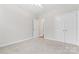 Bedroom showcasing neutral walls, carpeted floors, closet, and a white door at 132 Postell Dr, Statesville, NC 28625