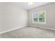 Bright bedroom features a ceiling fan, neutral walls, and a large window with views of the property at 132 Postell Dr, Statesville, NC 28625