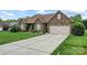 Brick home with a wide driveway and attached two-car garage, complemented by a well-maintained lawn at 132 Postell Dr, Statesville, NC 28625