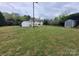 A wide shot of the backyard features a grassy lawn and two sheds at 1421 Van Nuys St, Salisbury, NC 28144
