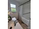 Bathroom view showcasing tub with shower, updated vanity, and natural light from window at 1421 Van Nuys St, Salisbury, NC 28144