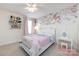 Stylish bedroom showcasing floral wallpaper, a white bed, and a charming vanity area with a fluffy pink rug at 15225 Kissimmee Ln, Mint Hill, NC 28227