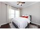 Comfortable bedroom with white bedding, modern ceiling fan, and bright natural light at 15225 Kissimmee Ln, Mint Hill, NC 28227