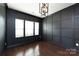 This empty dining room boasts paneled accent walls, hardwood floors, modern light fixture and natural light at 15225 Kissimmee Ln, Mint Hill, NC 28227