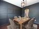 This dining room features an elegant light fixture, paneled accent wall, and a hardwood dining table at 15225 Kissimmee Ln, Mint Hill, NC 28227
