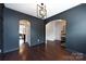 A dining room features dark accent walls, hardwood floors, and multiple arched doorways at 15225 Kissimmee Ln, Mint Hill, NC 28227