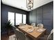 This dining room features an elegant light fixture, paneled accent wall, and an abundance of natural light at 15225 Kissimmee Ln, Mint Hill, NC 28227