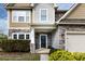 Inviting home entrance with decorative stone, a cozy porch, and manicured shrubs at 15225 Kissimmee Ln, Mint Hill, NC 28227