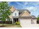 Charming home with stone and siding exterior, two-car garage, and mature landscaping at 15225 Kissimmee Ln, Mint Hill, NC 28227