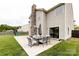A spacious patio with modern outdoor furniture, a stone fireplace, and backyard access at 15225 Kissimmee Ln, Mint Hill, NC 28227